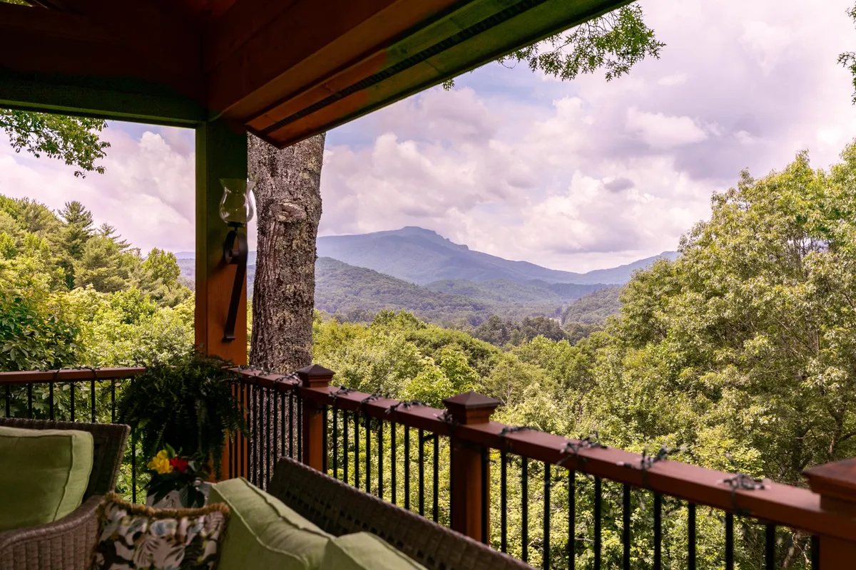 An outdoor seating area is surrounded by vibrant green foliage with an unobstructed view of the mountains. The tranquil, refreshing atmosphere invites guests and their dogs to enjoy nature together, from sunrises to stargazing.