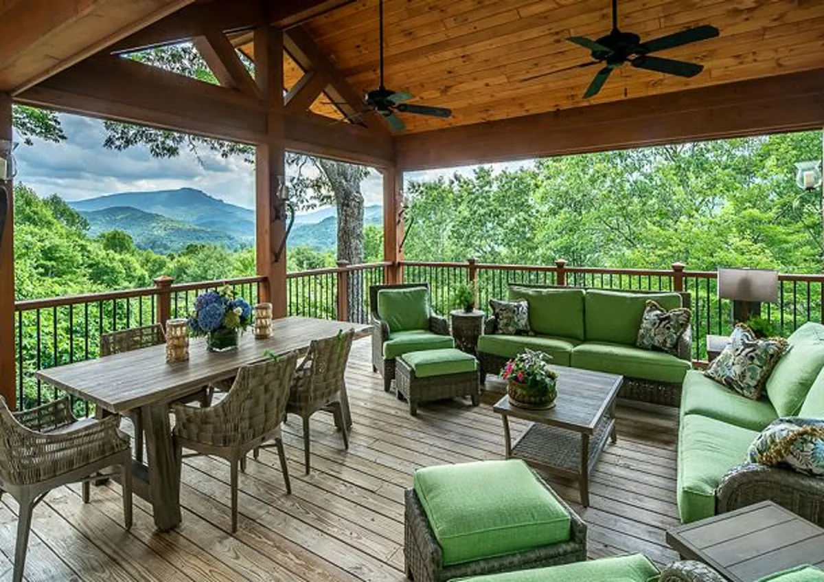 The image centers on an outdoor seating area with a dining table overlooking a breathtaking mountain backdrop. Elegant floral arrangements and comfortable furnishings create a welcoming space for hosting barbecues, enjoying morning coffee, or relaxing with a book.